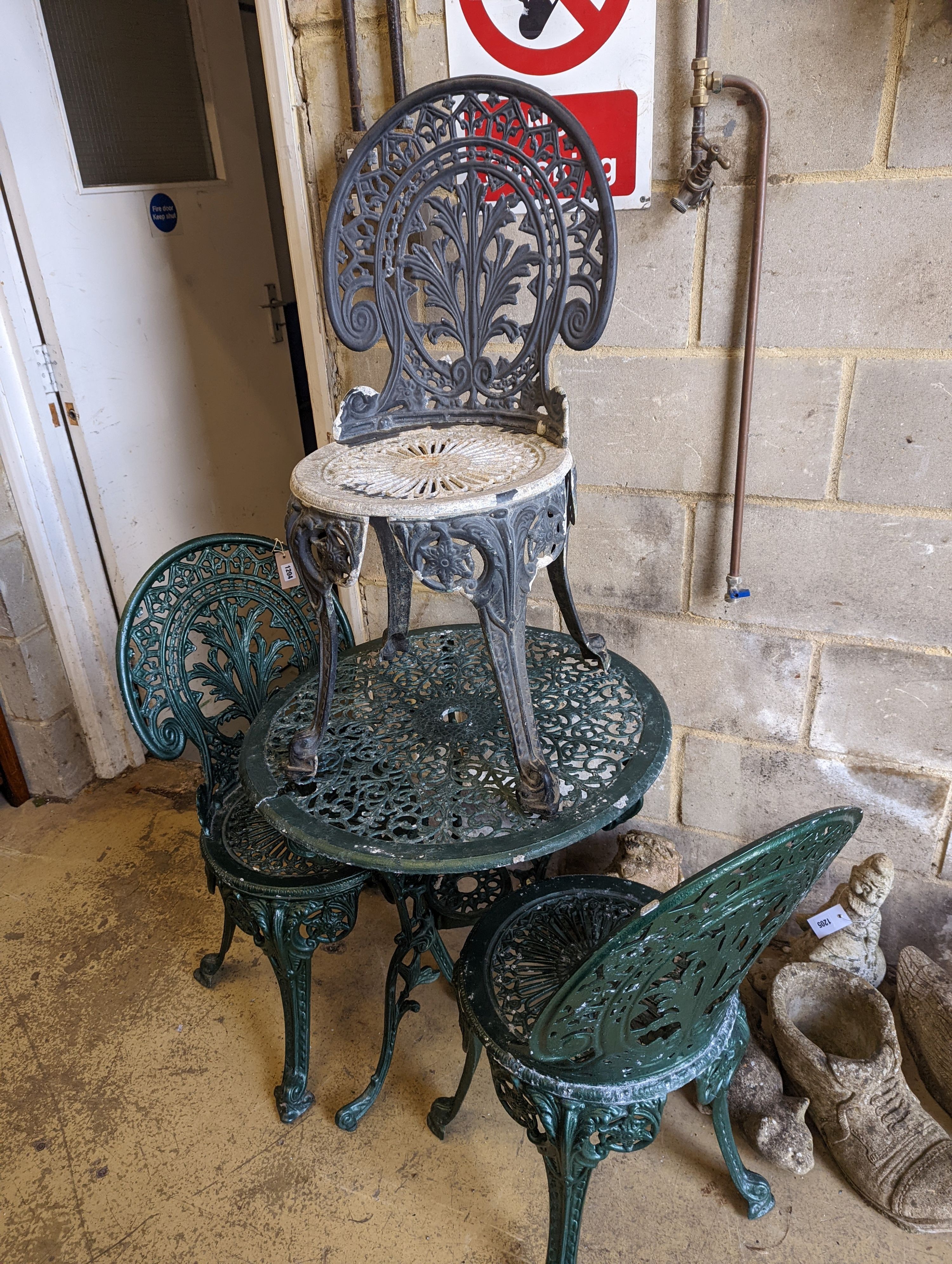 A circular painted aluminium garden table, diameter 65cm, together with three chairs